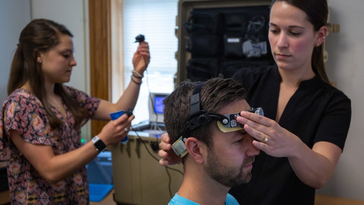 Researchers at the Gfeller Center affix an apparatus to a subject's head for concussion research