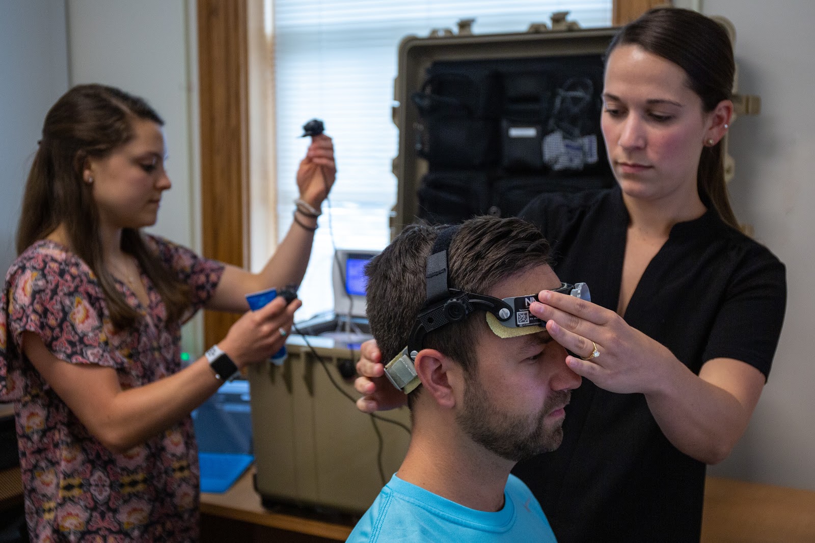 Researchers at the Gfeller Center affix an apparatus to a subject's head for concussion research