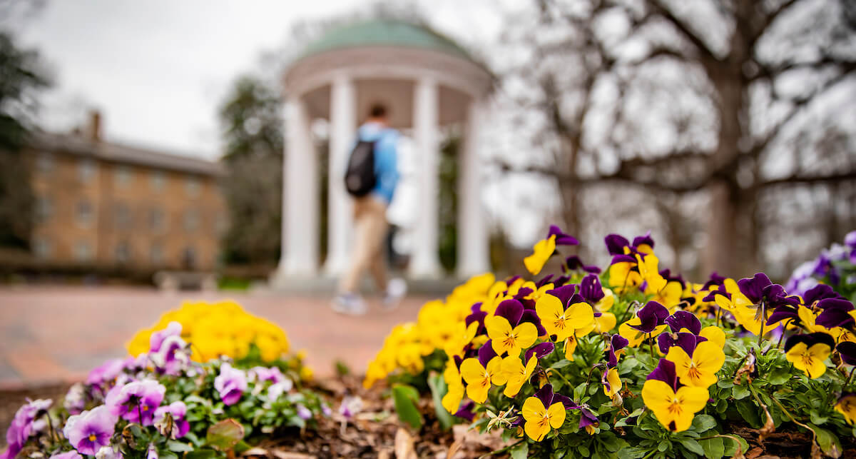 Student walks in front of the Old Well on the campus of UNC-Chapel Hill