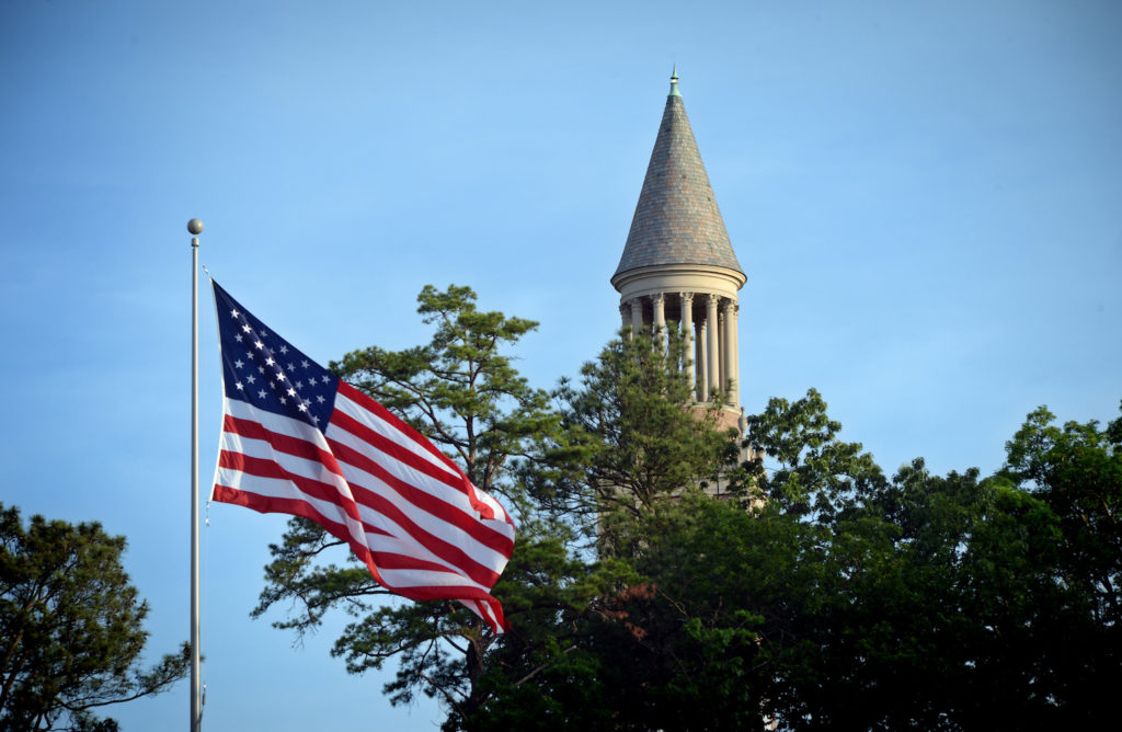 American flag with the Carolina bell tower in the background.