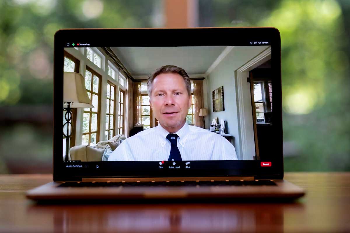 Chancellor Kevin Guskiewicz addresses students in a virtual meeting. Here he is shown on a laptop.