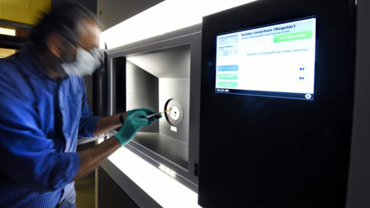 Researcher entering data into a machine.