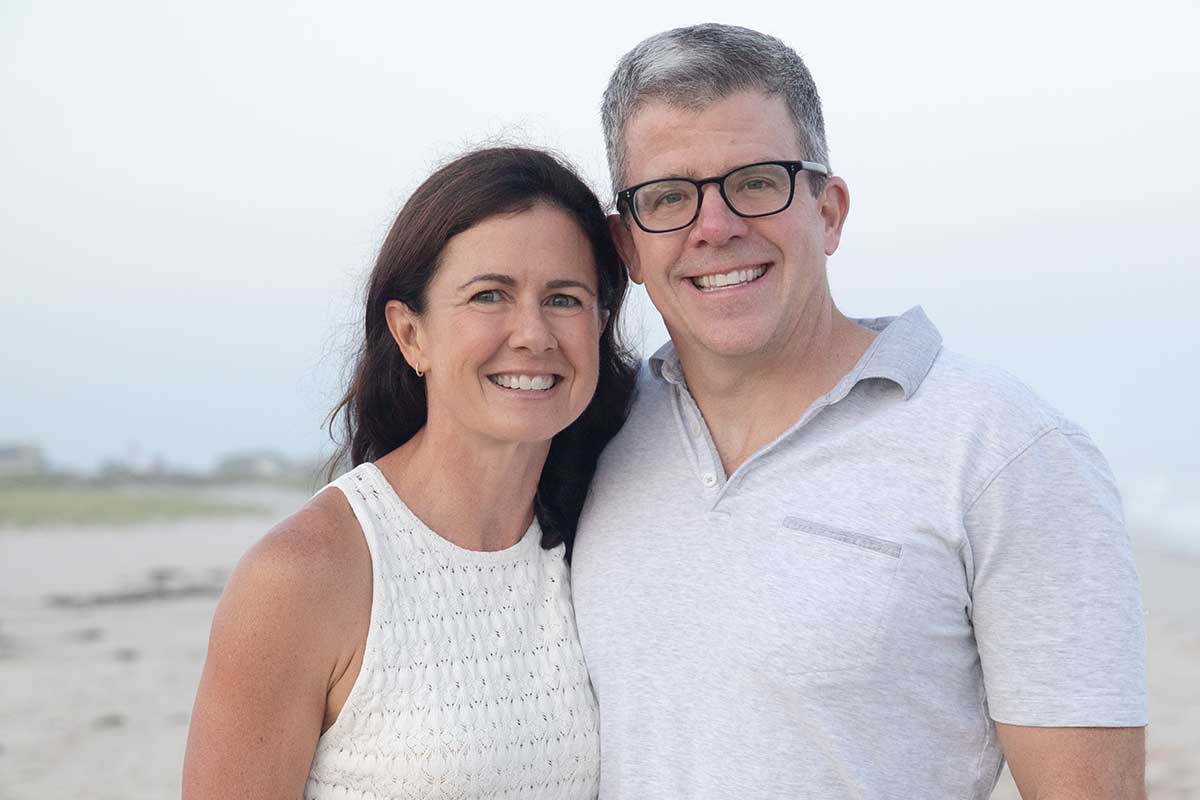 Vicki and David Craver pose together on a beach.