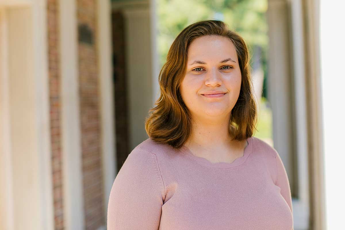 Carolina student Kaitlin Peck poses in front of the Old Well.