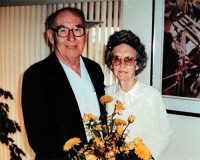 Paul and Ruth Freedle holding yellow flowers.
