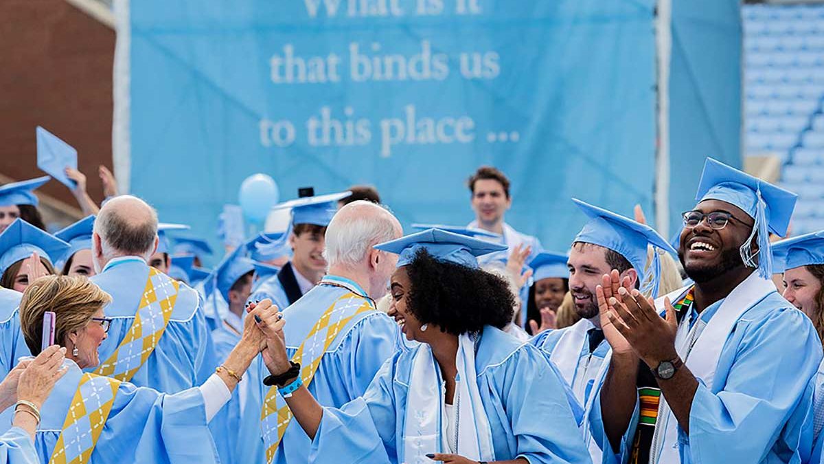 A group of Carolina graduates celebrate at a commencement ceremony.
