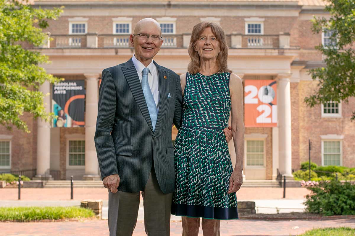 James and Susan Moeser pose outdoors in front of South Building on UNC-Chapel Hill's campus.