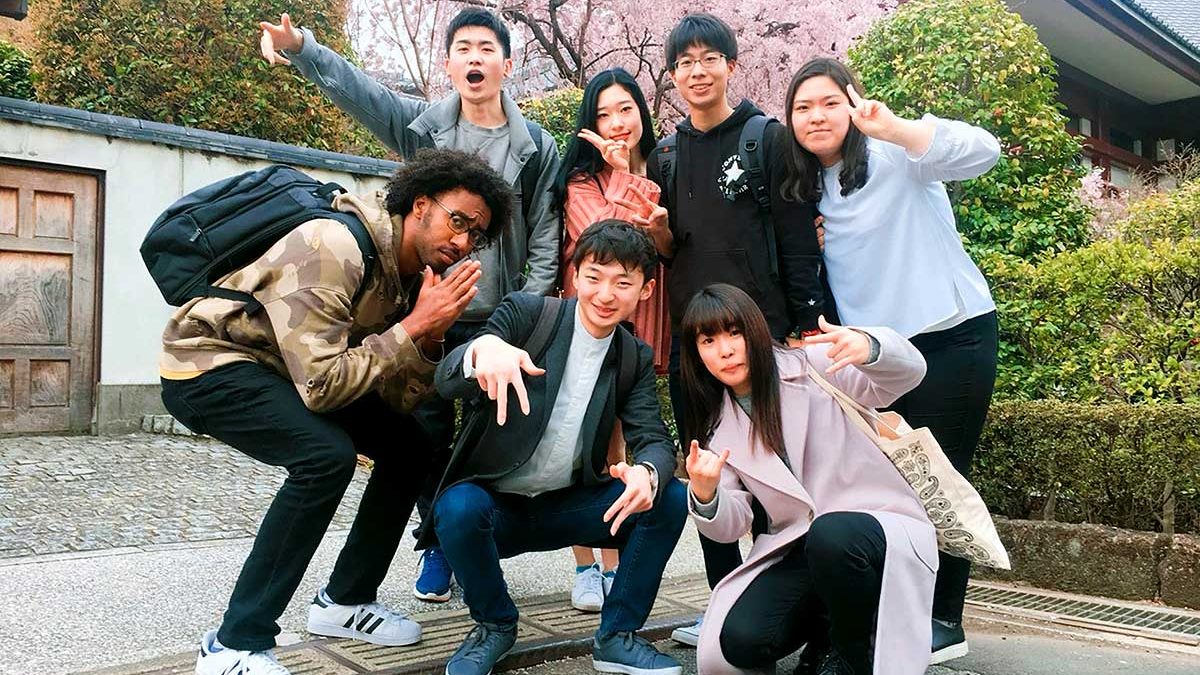 Phillips Ambassador T.J. Turner poses with some of his Korean and Japanese friends in Shiba Park with blooming cherry trees in the background.