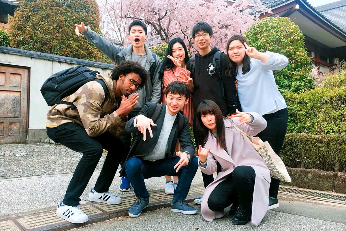 Phillips Ambassador T.J. Turner poses with some of his Korean and Japanese friends in Shiba Park with blooming cherry trees in the background.