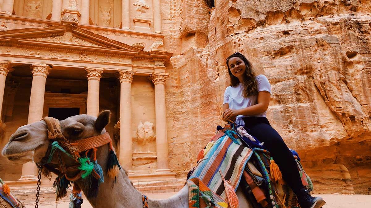 Morehead-Cain scholar Sarah Mackenzie sits atop a camel in Petra, Jordan.