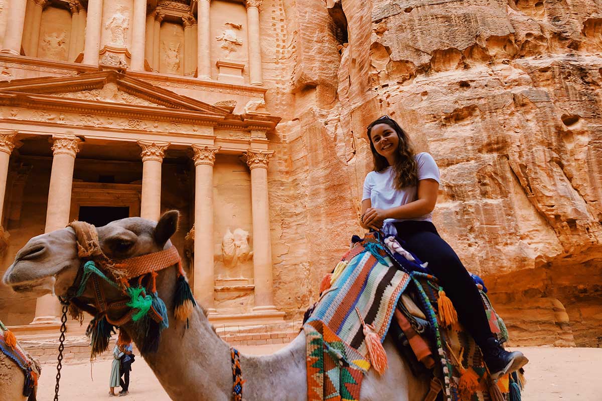Morehead-Cain scholar Sarah Mackenzie sits atop a camel in Petra, Jordan.