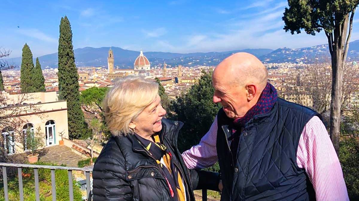 Susan Gravely and Bill Ross gaze at each other on a balcony overlooking the city of Florence.