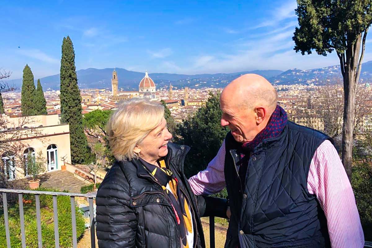 Susan Gravely and Bill Ross gaze at each other on a balcony overlooking the city of Florence.