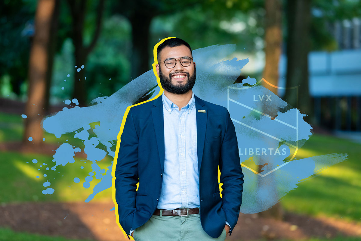 Carolina Covenant alum Larry Thi poses outside in front of a wooded park.