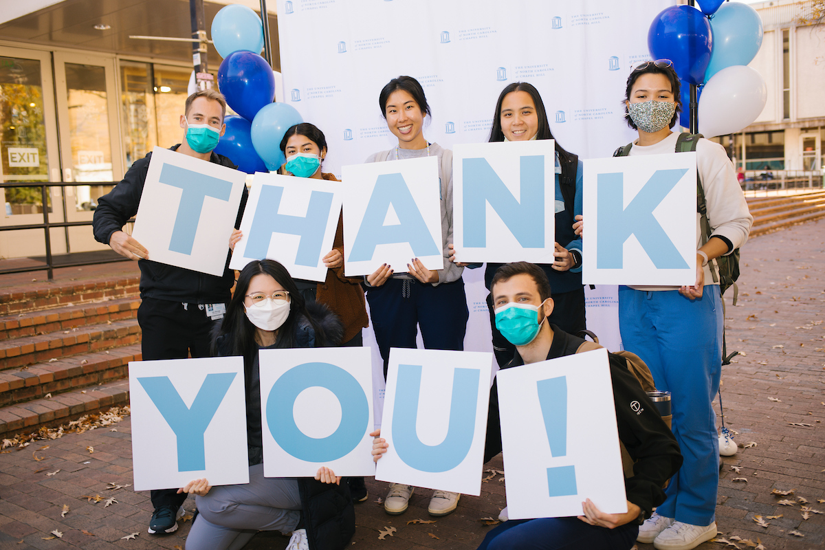 UNC students holding up a signs that spell out Thank You!