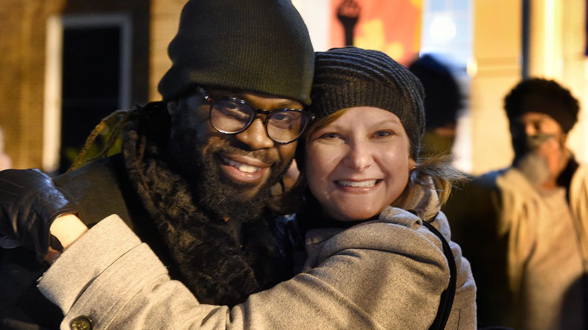 CJ Suitt and Heather Trateau hug and smile at the camera at Peace and Justice Plaza at UNC-Chapel Hill