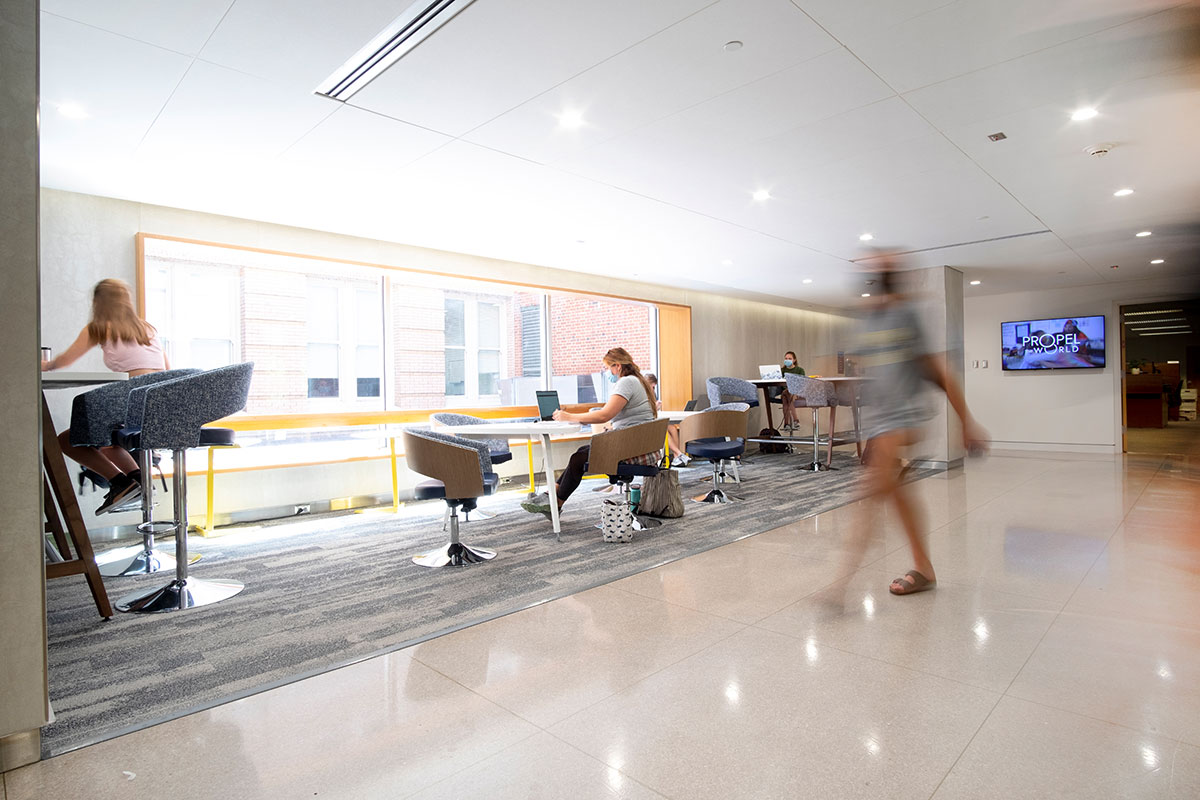 A blurry person walks down a corridor.