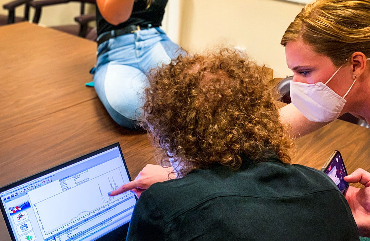 Epidemiology doctoral student Mary Figgatt looks at a graph on a computer screen