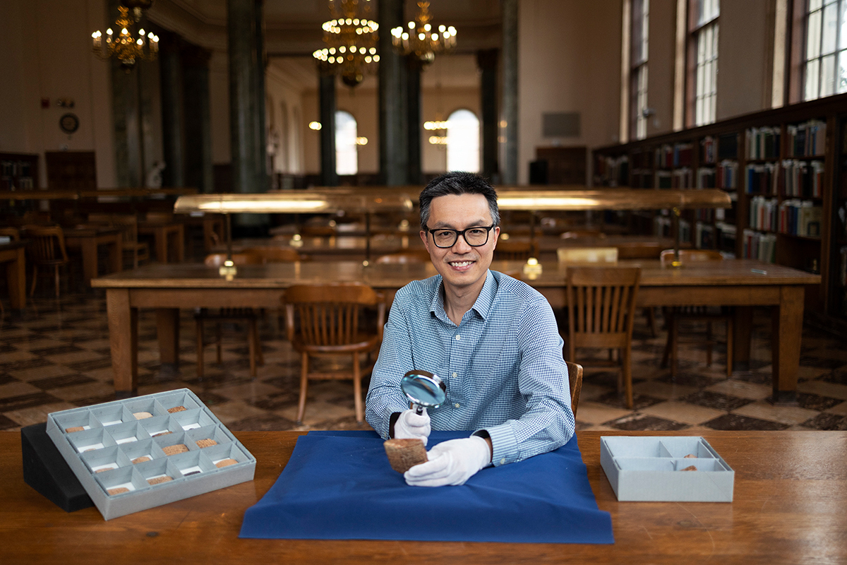 Lam in the Fearrington Reading Room with ancient cuneiform tablets.
