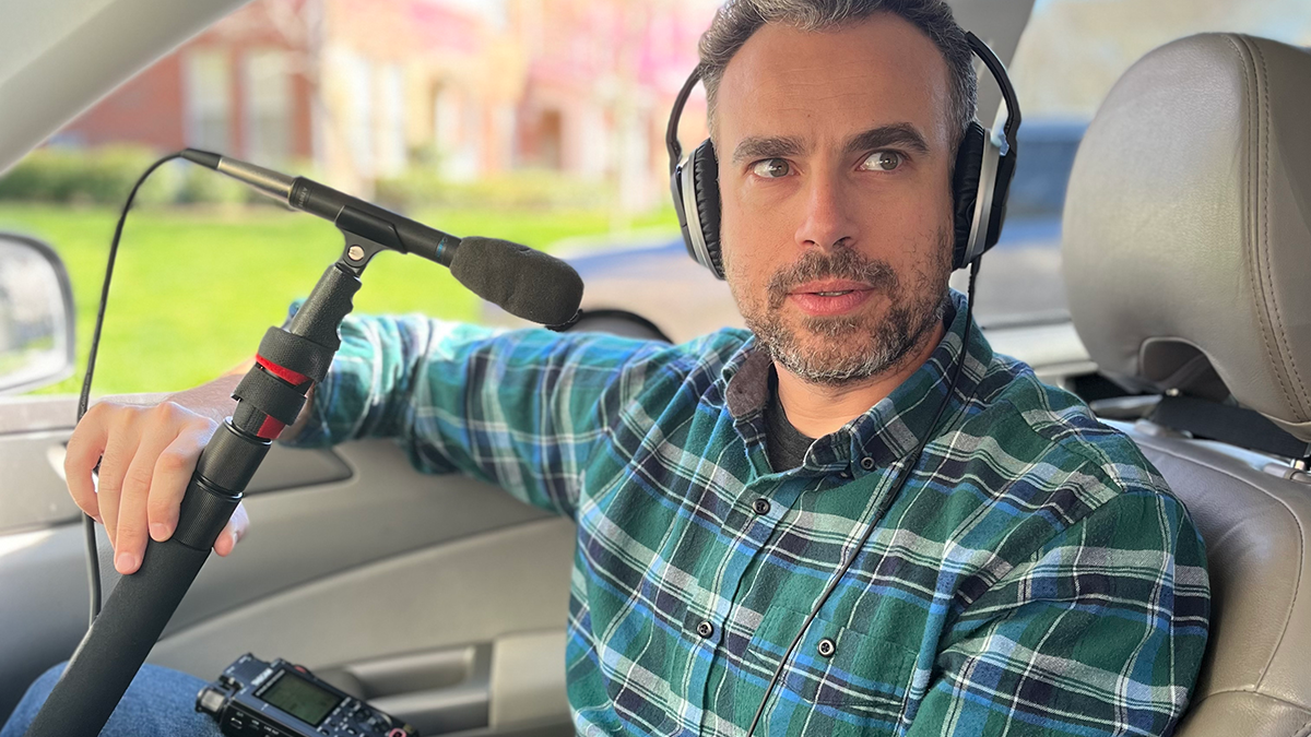 Isaac Klein sits in his car with recording equipment