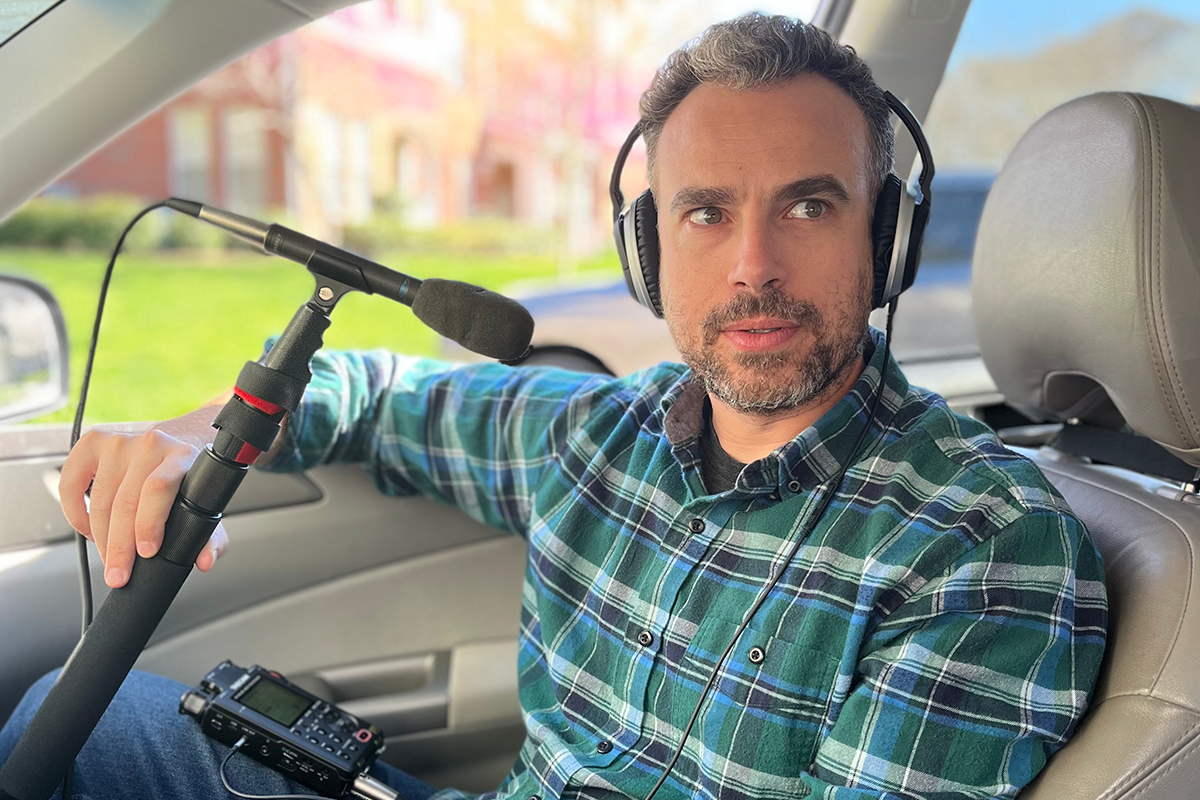 Isaac Klein sits in his car with recording equipment