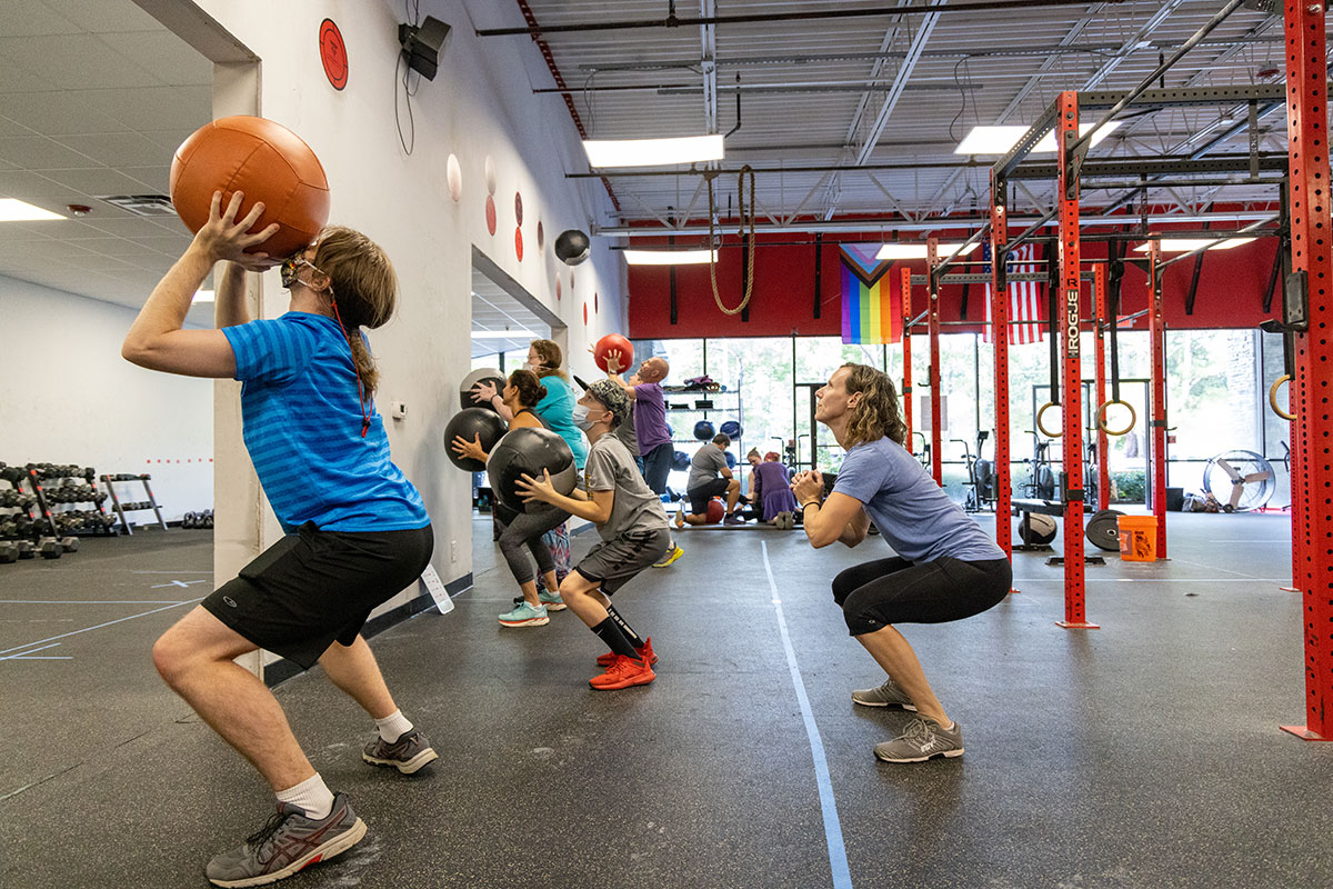 Kara Hume does squats with athletes in her adaptive fitness class