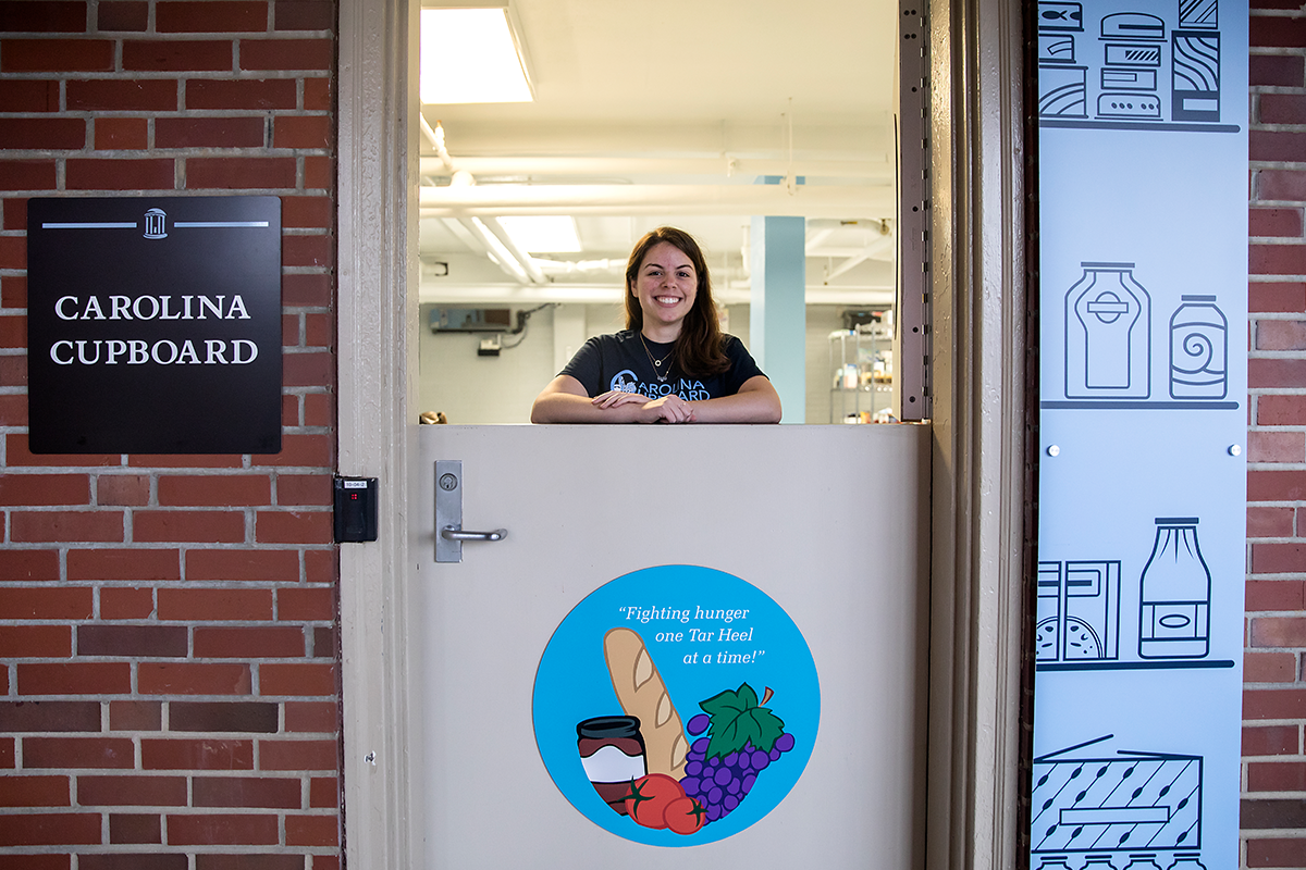 A shift leader stands in front of the Carolina Cupboard
