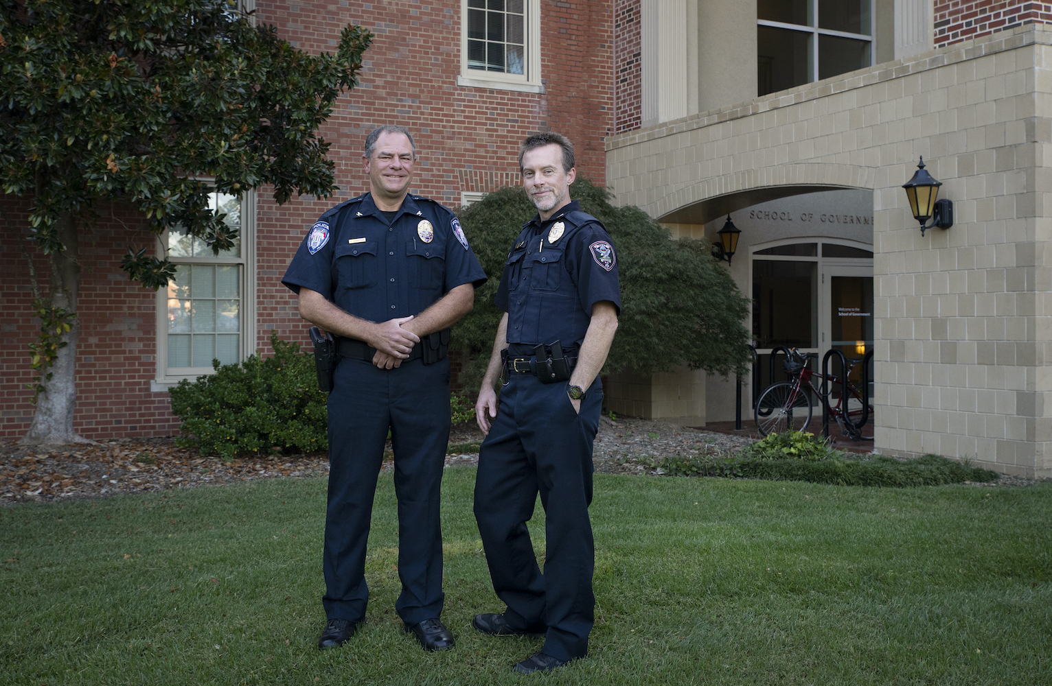 Chris Atack and Duane Hampton in police uniforms pose at the UNC School of Government.