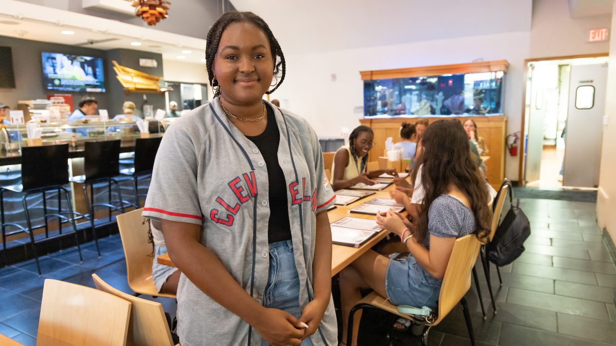 Morehead-Cain Scholar Kendall Leigh stands in front of a dining table at a sushi restaurant.