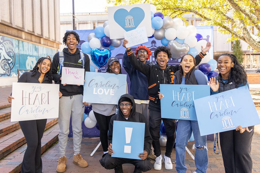 Students holding up signs thanking donors at the GiveTHANKS 2022 event in the Pit at UNC-Chapel Hill.