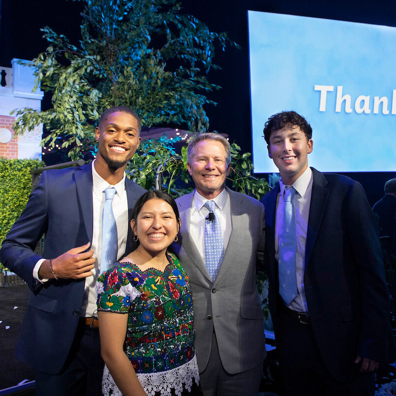 Carolina students RIghteous Keitt, Brenda Rodriguez and Landon Collins stand with Chancellor Kevin Guskieiwicz in front of a sign saying 'Thank you' to donors